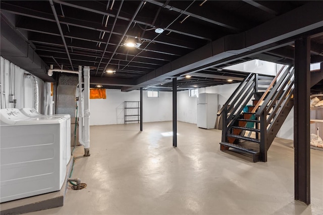 basement with white fridge and independent washer and dryer