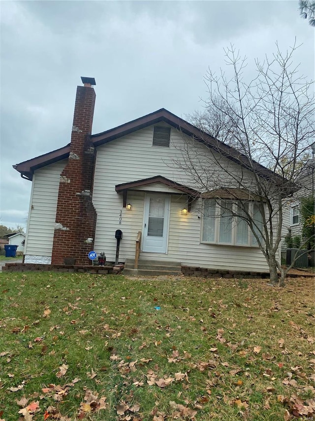 rear view of property featuring a lawn