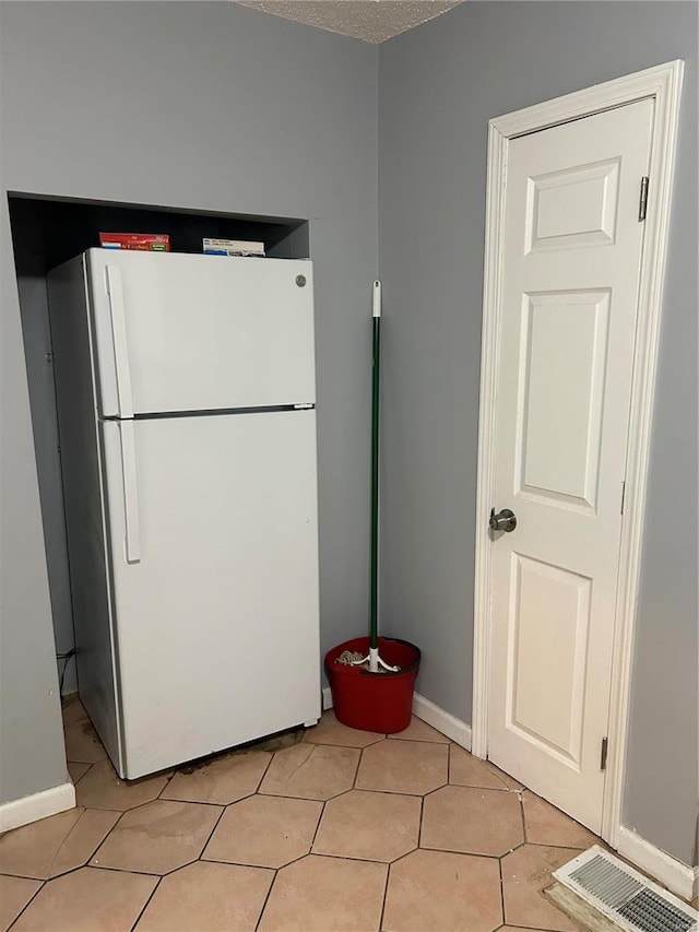 kitchen with white fridge and a textured ceiling