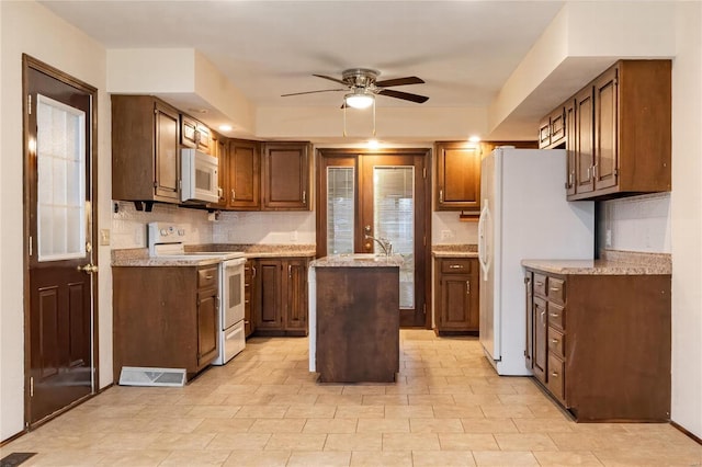 kitchen with french doors, tasteful backsplash, white appliances, ceiling fan, and a center island