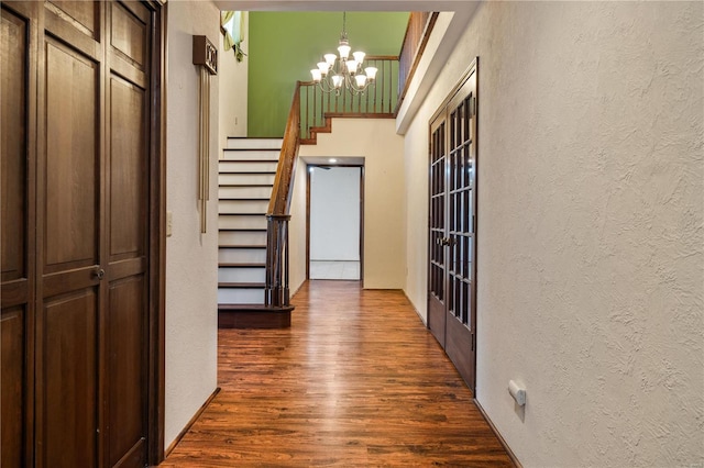 hall with dark hardwood / wood-style flooring and a chandelier