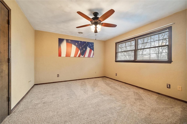 spare room featuring ceiling fan and light colored carpet