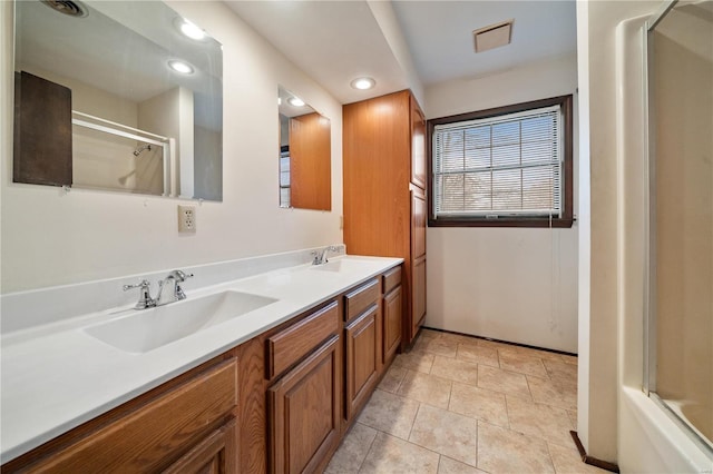 bathroom with tile patterned flooring, vanity, and combined bath / shower with glass door