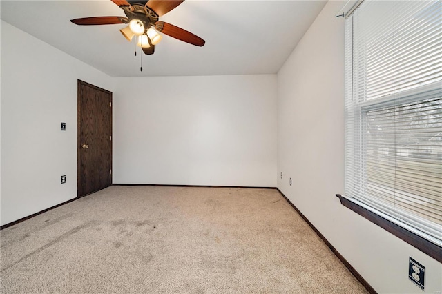 carpeted spare room featuring ceiling fan