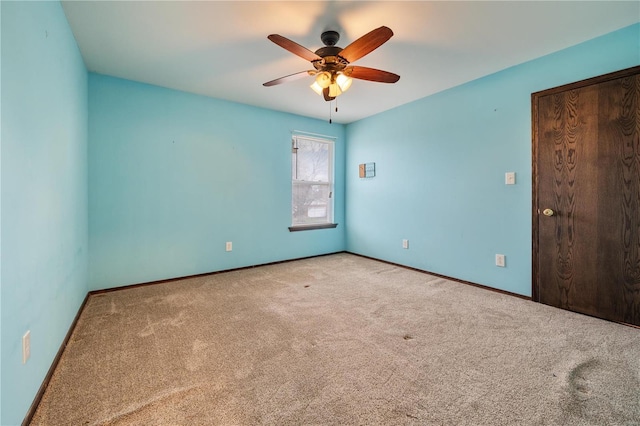 empty room featuring ceiling fan and light carpet