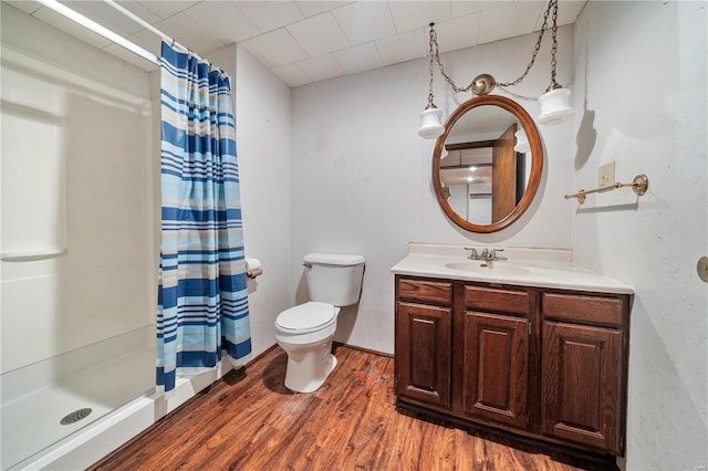 bathroom featuring toilet, hardwood / wood-style floors, vanity, and walk in shower