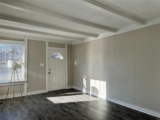 entrance foyer with beamed ceiling, dark wood-type flooring, and a textured ceiling