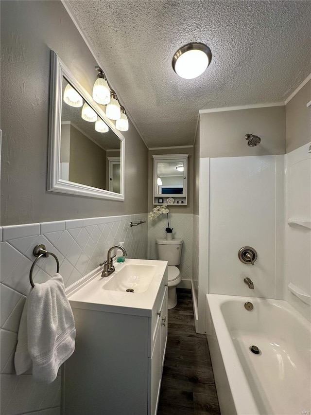 full bathroom with vanity, shower / washtub combination, hardwood / wood-style flooring, tile walls, and a textured ceiling