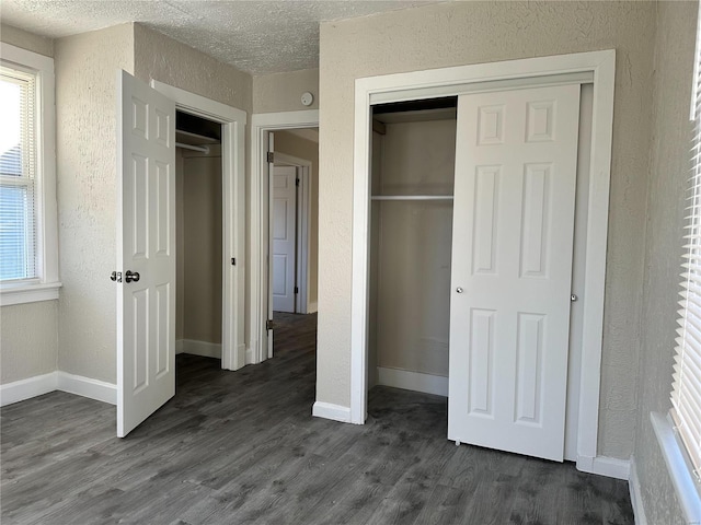 unfurnished bedroom featuring a textured ceiling and dark wood-type flooring