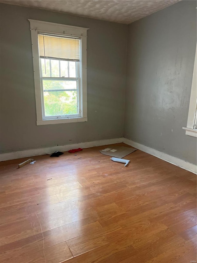 unfurnished room featuring a textured ceiling and light wood-type flooring