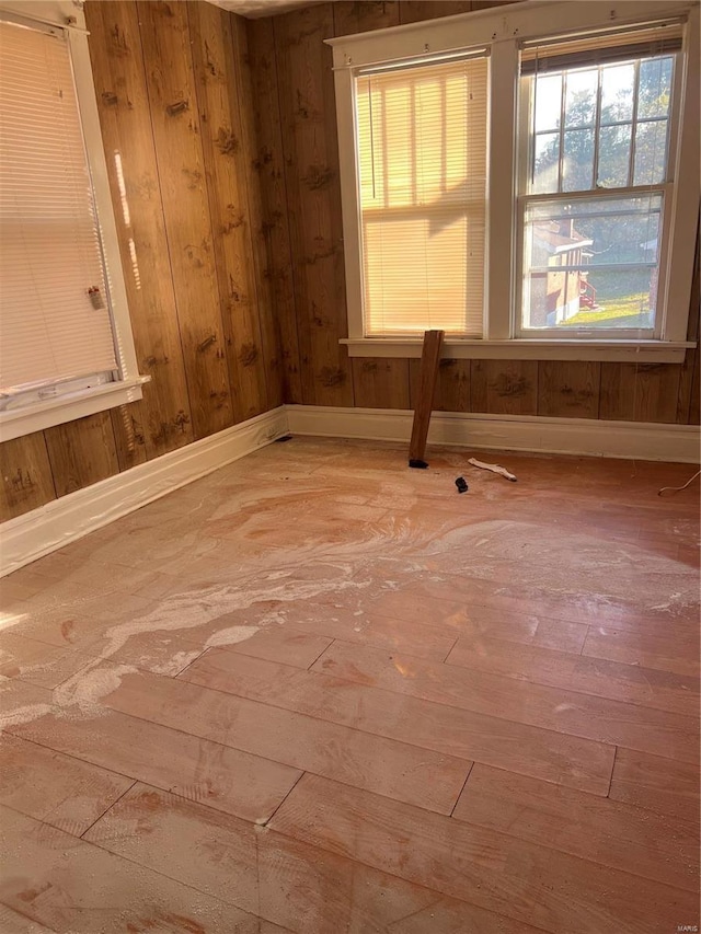 empty room with wood walls and wood-type flooring