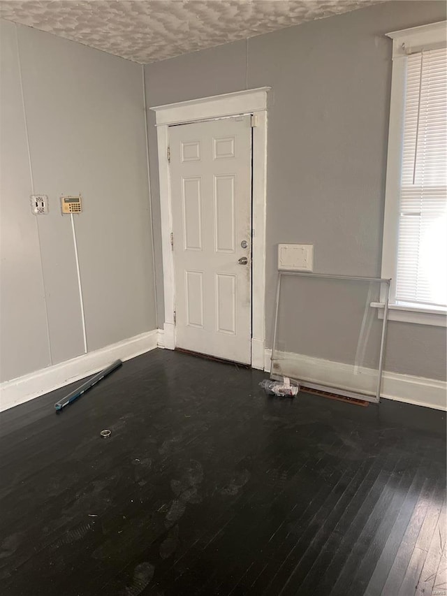 entrance foyer with dark hardwood / wood-style floors and a textured ceiling