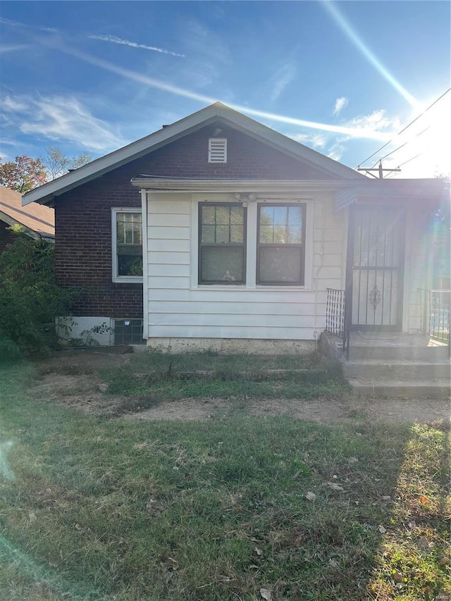 view of side of home with a lawn