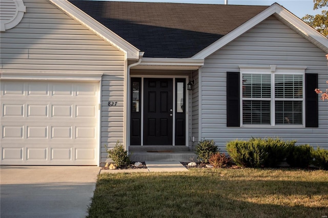 property entrance featuring a garage and a yard