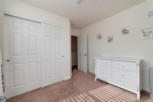 unfurnished bedroom with ceiling fan, light colored carpet, and a closet