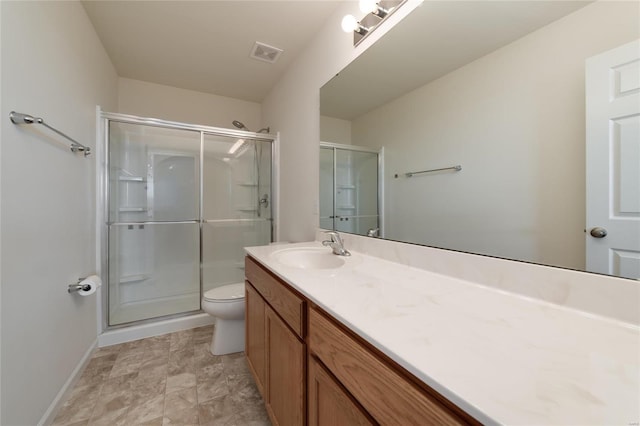 bathroom featuring vanity, an enclosed shower, and toilet