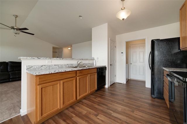 kitchen with lofted ceiling, sink, light stone counters, black appliances, and kitchen peninsula