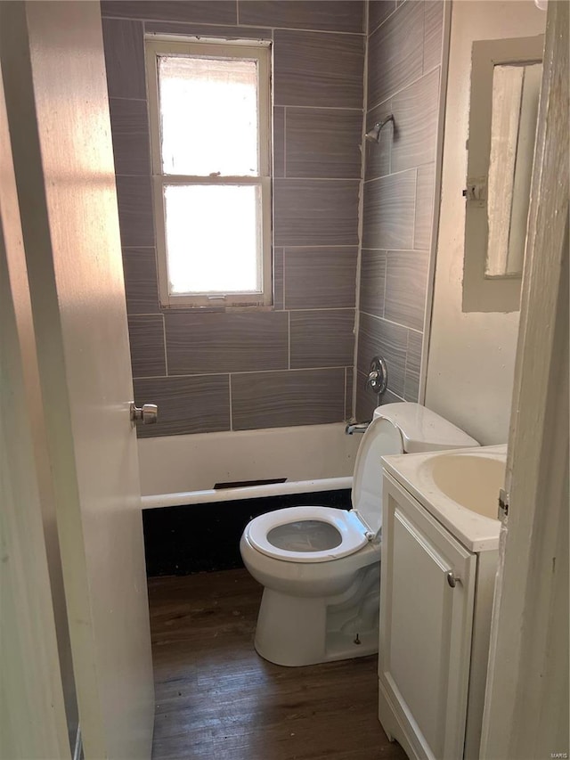 full bathroom with hardwood / wood-style flooring, vanity, toilet, and tiled shower / bath combo