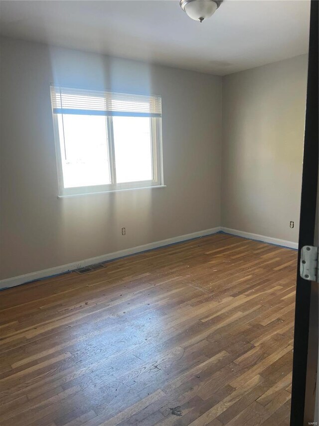 spare room featuring dark wood-type flooring