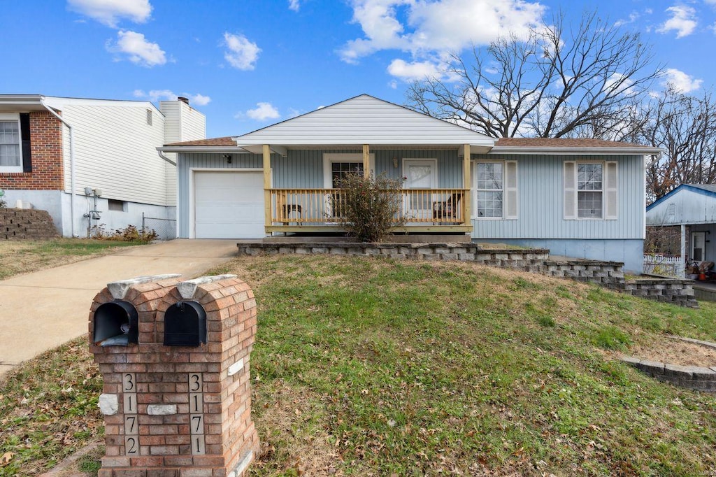 view of front facade featuring a front yard, a garage, and covered porch