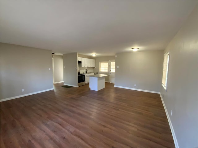 unfurnished living room featuring dark hardwood / wood-style flooring and sink