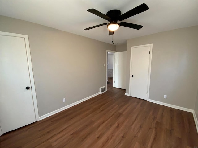 unfurnished bedroom featuring dark hardwood / wood-style floors and ceiling fan