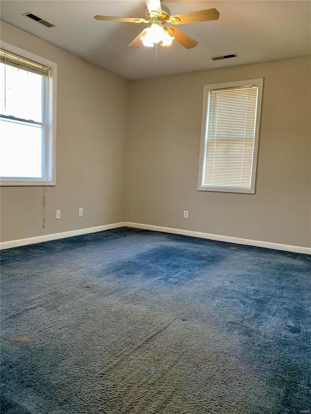 carpeted spare room with ceiling fan