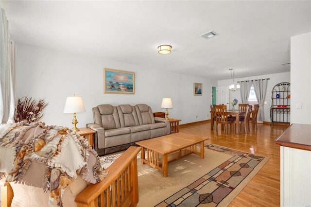 living room featuring a notable chandelier and light wood-type flooring