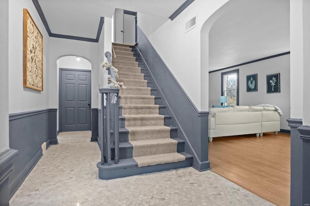 staircase with crown molding and hardwood / wood-style floors