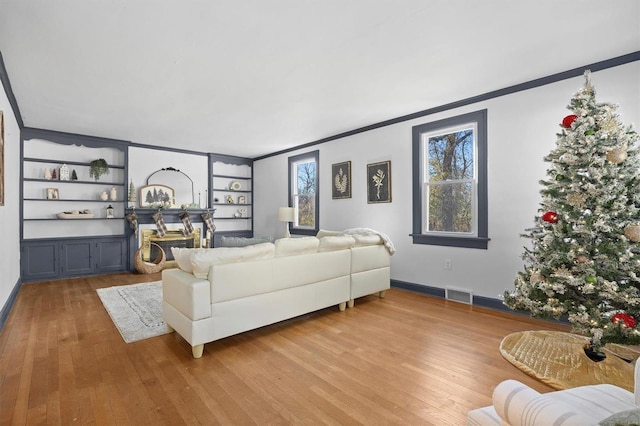 living room with crown molding and light hardwood / wood-style flooring