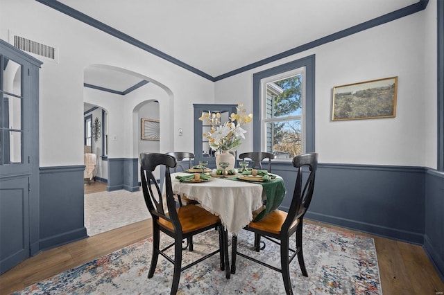 dining area with dark hardwood / wood-style flooring and crown molding