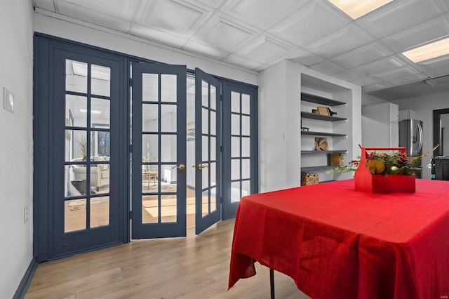 dining area featuring built in shelves, french doors, and light hardwood / wood-style floors