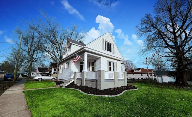 view of side of home with a lawn and a porch