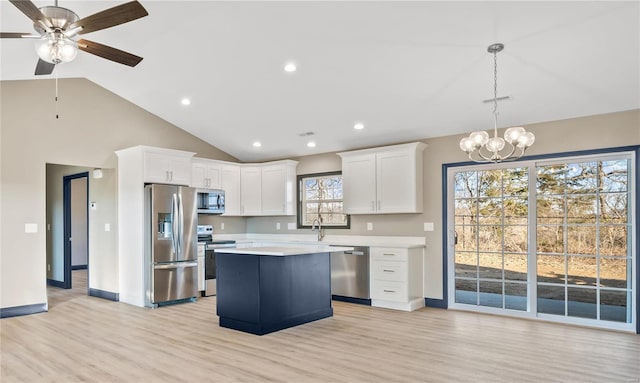 kitchen with light hardwood / wood-style flooring, hanging light fixtures, a kitchen island, stainless steel appliances, and white cabinets