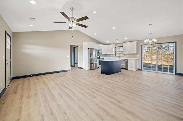 unfurnished living room featuring sink, ceiling fan with notable chandelier, vaulted ceiling, and light hardwood / wood-style floors