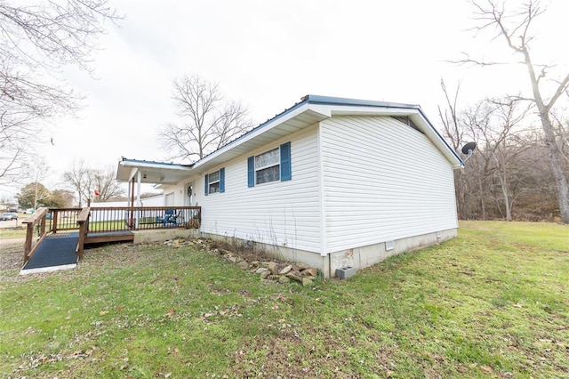 view of side of property with a deck and a lawn