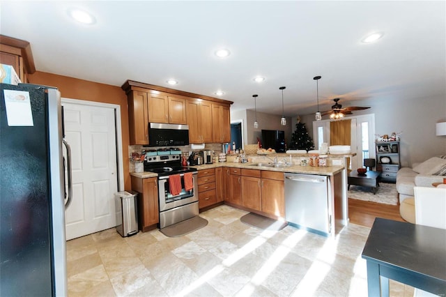 kitchen with ceiling fan, stainless steel appliances, kitchen peninsula, pendant lighting, and decorative backsplash