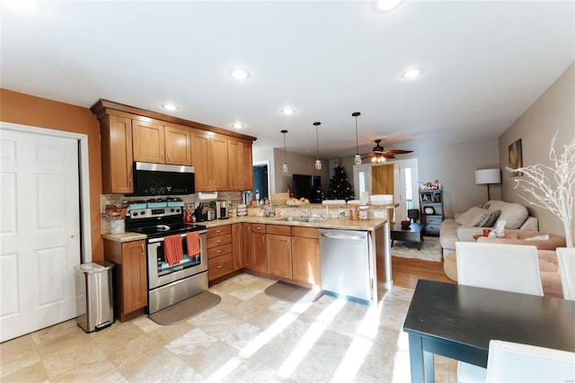 kitchen featuring ceiling fan, hanging light fixtures, tasteful backsplash, kitchen peninsula, and appliances with stainless steel finishes