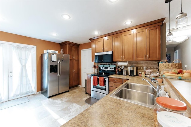 kitchen with appliances with stainless steel finishes, decorative light fixtures, tasteful backsplash, and sink