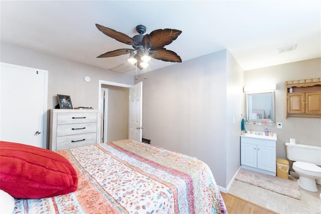 bedroom with ceiling fan, light hardwood / wood-style floors, and connected bathroom