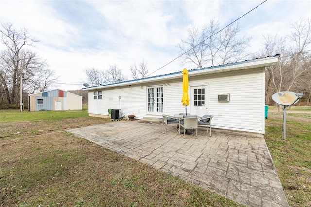 back of house featuring a lawn, french doors, an outdoor structure, central AC unit, and a patio area