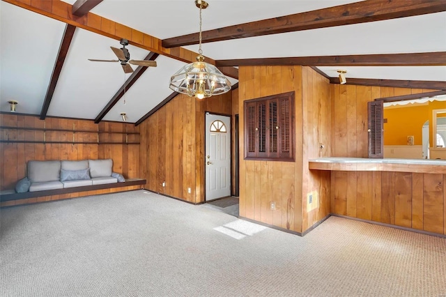 kitchen with wooden walls, lofted ceiling with beams, hanging light fixtures, and light carpet