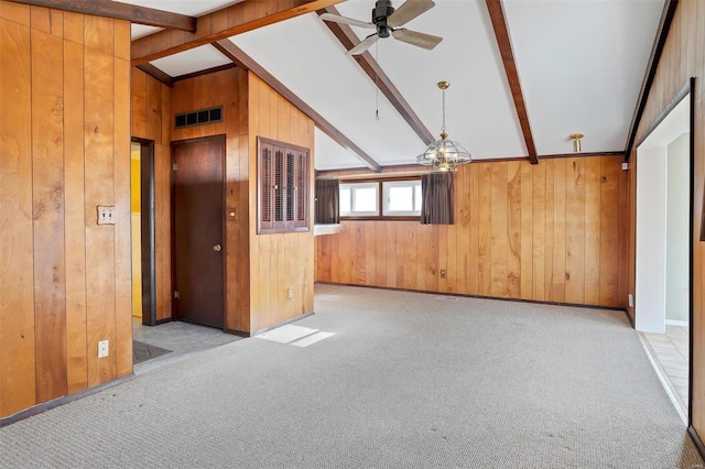 unfurnished living room with light carpet, vaulted ceiling with beams, ceiling fan, and wood walls