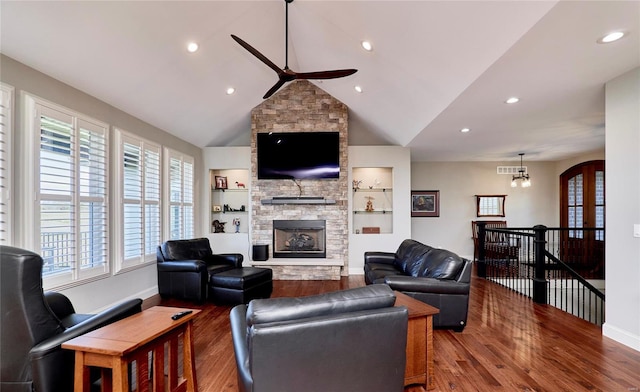 living room with visible vents, wood finished floors, a fireplace, baseboards, and ceiling fan