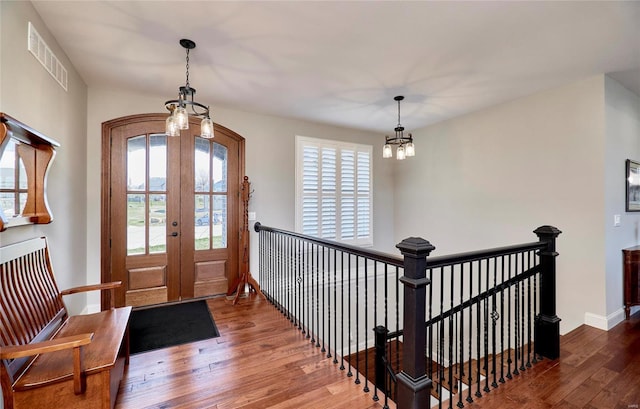 foyer featuring visible vents, hardwood / wood-style flooring, french doors, baseboards, and a chandelier