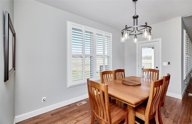 dining room featuring visible vents, baseboards, and wood finished floors