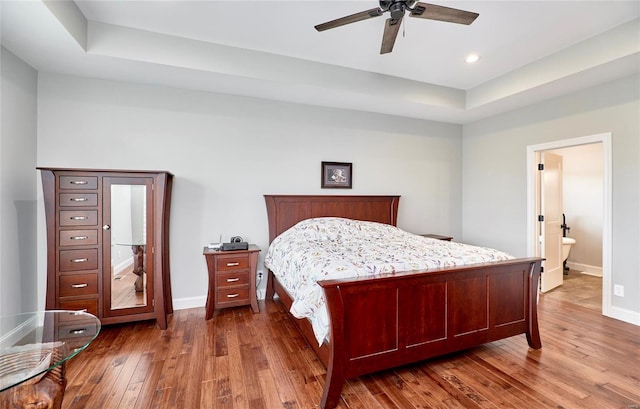 bedroom with a ceiling fan, baseboards, recessed lighting, dark wood-type flooring, and a raised ceiling