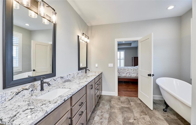 full bath with double vanity, a soaking tub, ensuite bath, and a sink