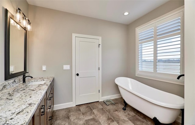 full bath with recessed lighting, baseboards, a soaking tub, and vanity