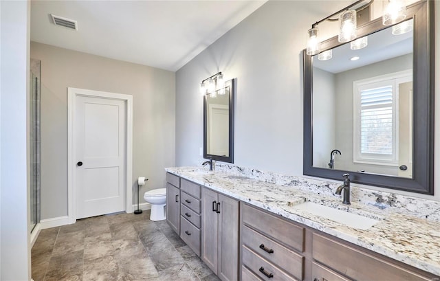 full bath with a sink, visible vents, toilet, and double vanity